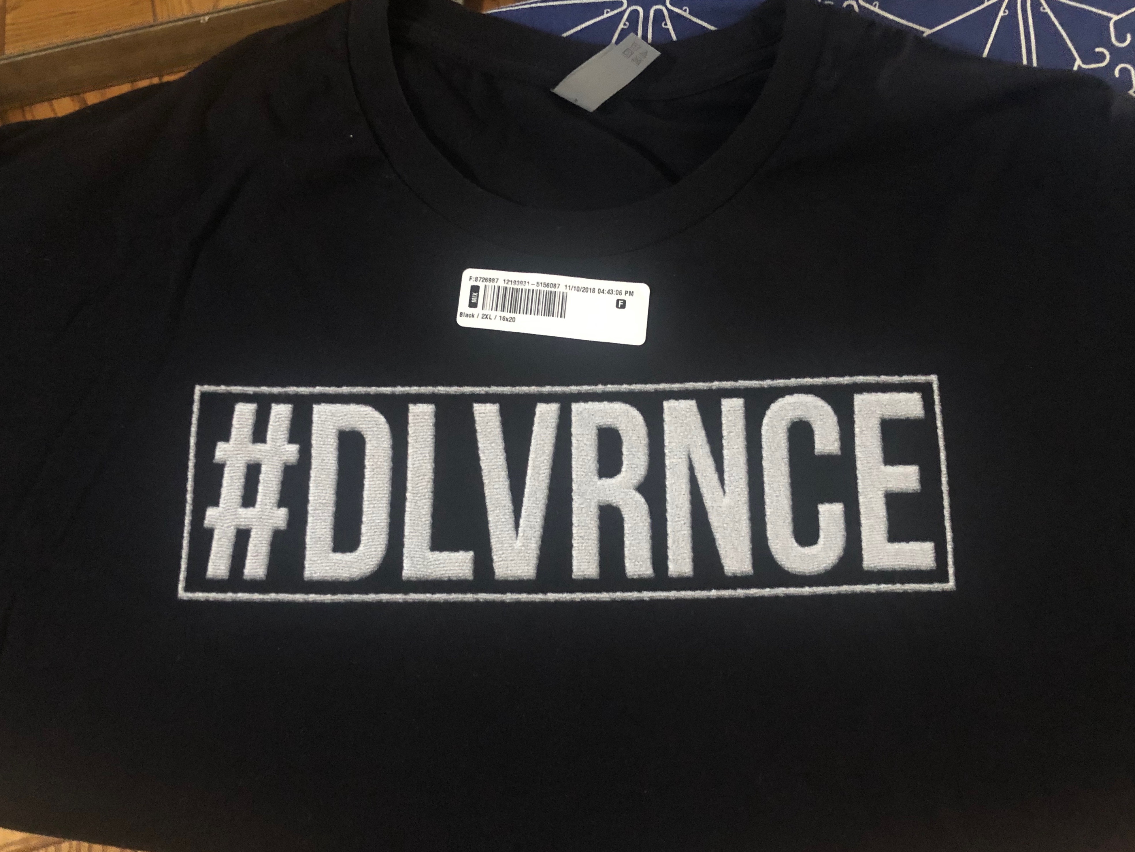A black shirt with the word # dlvrnce on it.