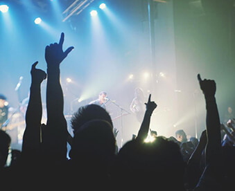 A crowd of people at an event with their hands in the air.