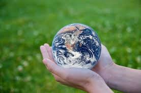 A person holding an earth globe in their hands.
