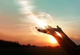 A person 's hands reaching up to the sun.