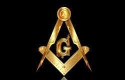 A golden masonic symbol with the letter g.