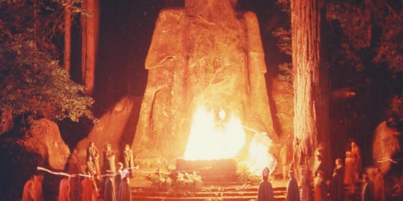 A fire is burning in front of an ancient statue.