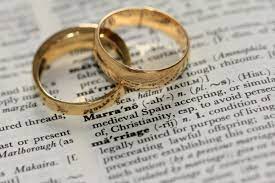 Two wedding rings on top of a dictionary page.